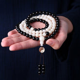 Ebony Yin Yang Protection Mala - black and white beads held in hands with yin-yang, 108 bead necklace