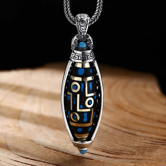 Nine-Eye Dzi Bead Pendant - Angled view of silver-framed bead with gold inlay and turquoise