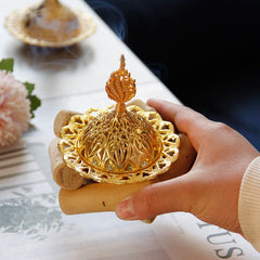 Gold Alloy Mini Incense Burner – flame finial lid on wooden stand held in hand with smoke, gold metal incense holder