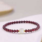 Natural garnet jade purification bracelet featuring deep wine-red garnet beads with a central white jade focal bead and gold spacer accents, displayed on white background