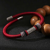 Om Mani Padme Hum Red Bracelet – Low angle of red braided cord with silver filigree bead, Buddhist charm bracelet