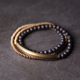 Lava Rock Copper Healing Bracelet – Black volcanic stone beads with copper-toned metal accents and silver wire-wrapped focal on gray textured stone, low side angle