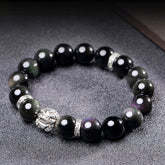 Rainbow Obsidian Bracelet – Silver PiXiu on textured gray surface, iridescent black beads, blessing
