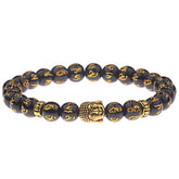 Tibetan Buddha Om Mani Padme Hum Amulet Bracelet - black obsidian beads with gold Tibetan mantra inscriptions, central gold Buddha head amulet charm, gold spacer beads, stretch prayer bracelet on white background