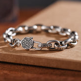 Om Mani Padme Hum Silver Bracelet – Macro shot of lotus clasp with Sanskrit engravings on oxidized silver chain, spiritual jewelry