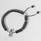 Coconut Shell Dorje Vajra Bracelet – Top-down view of full bracelet with dark beads and silver vajra charm, prayer bracelet