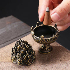 Copper Incense Burner Disassembled – Lid removed with hand placing cone incense, showing interior on textured fabric surface