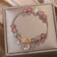 Strawberry Quartz Moonstone celestial charm bracelet with pink and gray-blue gemstone beads, gold moon and star pavé crystal charms in champagne gift box.