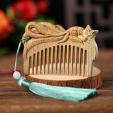 Green sandalwood hand-carved fox comb with light blue tassel on wooden stand