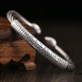 Tibetan Heart Sutra Cuff Bracelet – engraved mantra panel on dark wood, dramatic lighting, Buddhist silver jewelry