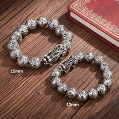 Tibetan Feng Shui PiXiu Silver Bracelet – Two-tone comparison showing 15mm and 12mm sizes with carved Pixiu charms and Bagua beads on brown wood background