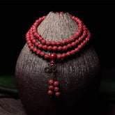 108 Mala Beads Cinnabar Bracelet – Draped on ceramic vase, red prayer beads necklace