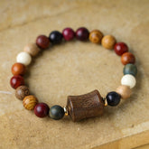 Multicolored Sandalwood Prayer Bracelet – Single strand flat lay on kraft surface, multi-wood beads