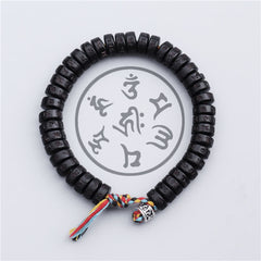 Coconut Shell Mantra Bracelet - Top-down circular view of carved mantra discs, five-color Buddhist tassel