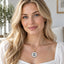 Gold Enamel Sunburst Evil Eye Necklace – Worn at the collarbone on a white blouse, enamel disc facing forward