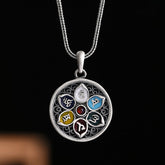 Om Mani Padme Hum Silver Purity Necklace – Silver circular pendant with six colored enamel Sanskrit syllables around central red gem on rope chain, black background
