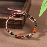 Woven Cotton Bracelet – multicolor braided cord with gold mantra barrel bead and orange agate on wood, Tibetan accessory