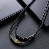 Dzi Bead Necklace – black braided wax rope with gold barrel bead and black hexagon spacers on leather, Tibetan necklace