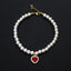 Crystal Heart Pet Necklace – Single strand pearl collar with red heart rhinestone pendant on black background