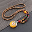 Wenge Mala Necklace – 108 wooden beads with yellow donut pendant in silver setting red accent, wood background