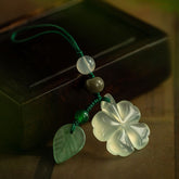 Jade Clover Keychain – white jade four-leaf clover with green leaf charm on dark wooden box