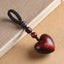 Rosewood Heart Keychain – carved heart with braided loop, wooden beads and brass ring on aged paper