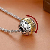 Taoist Nine-Character Mantra Copper Pendant – Silver rotating sphere with gold inscribed band and openwork cloud patterns on rope chain, tan leather surface