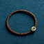 Braided cord bracelet with decorative bead, flat lay