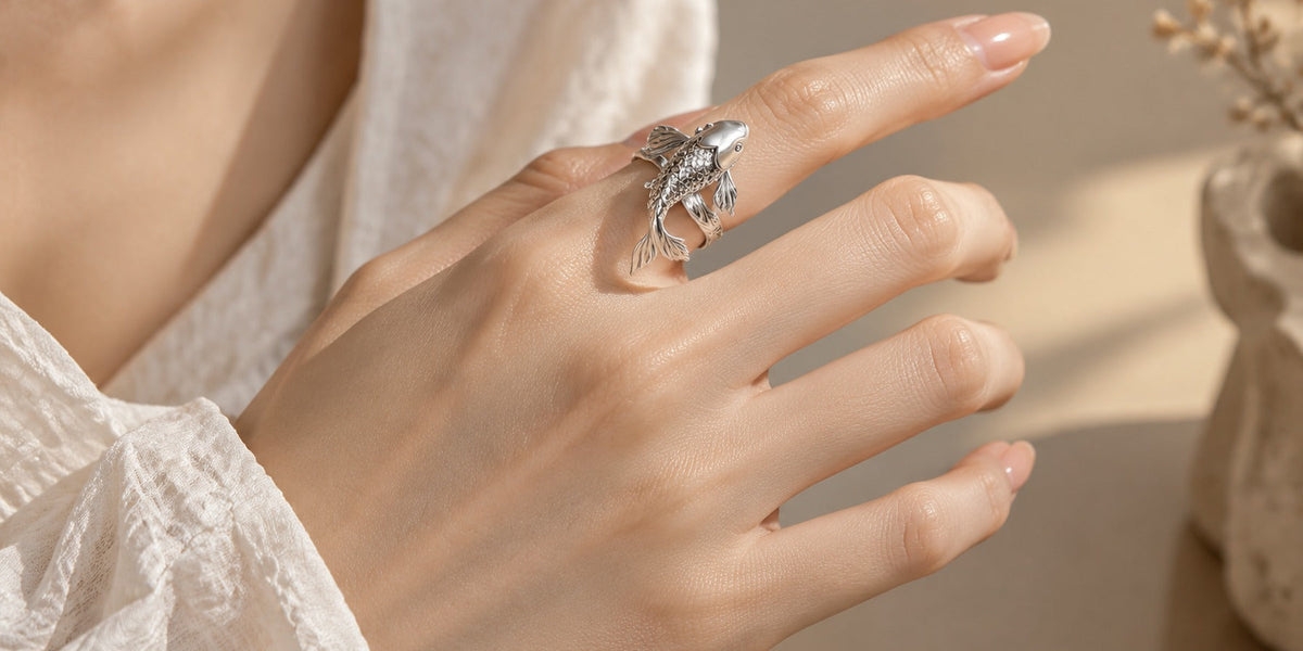 Silver koi fish ring worn on the index finger