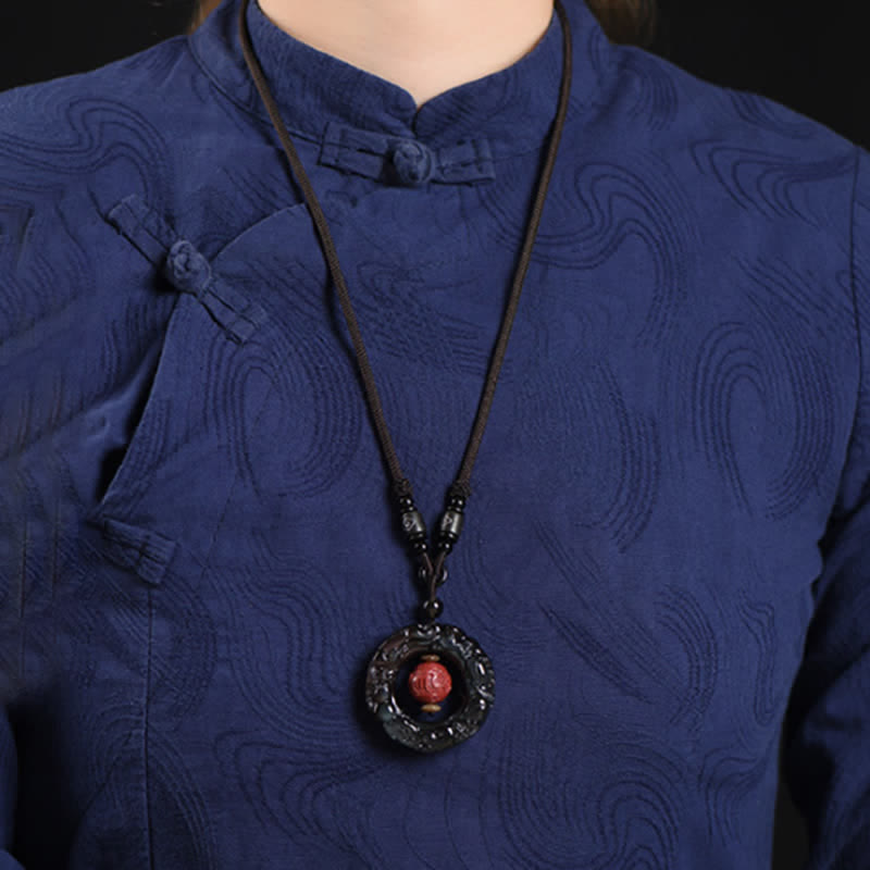 Rainbow Obsidian PiXiu Pendant – Woman wearing rainbow obsidian pendant with blue traditional top