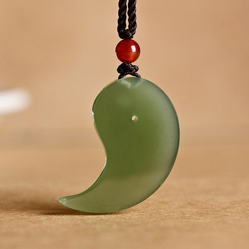 Yin Yang Jade Necklace – Front view of polished green jade curved pendant with red agate bead detail