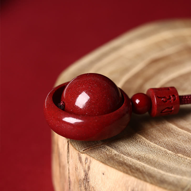 Cinnabar PiXiu Necklace – Side angle bead inside ring on wood slice red background, prosperity pendant