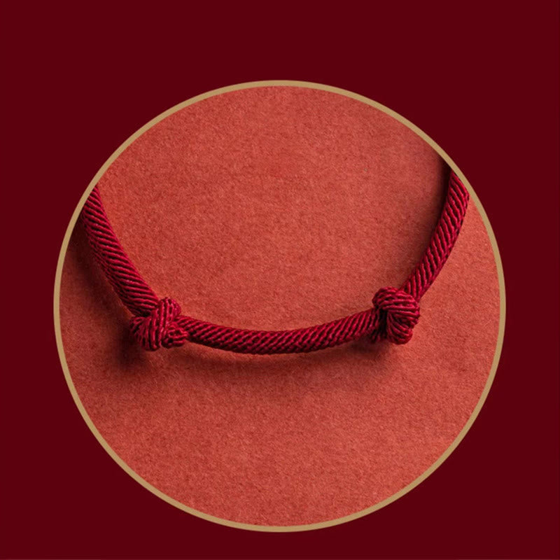 925 Silver Fu Character Braided Bracelet – Close-up of symmetrical burgundy cord knots on textured coral-red circular inset with gold border, decorative presentation