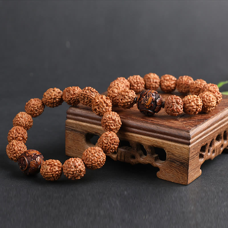 Rudraksha PiXiu Bracelet – Two bracelets on carved wooden stand, dark background, stacked wealth