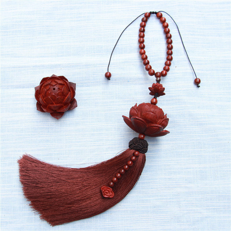 Red Sandalwood Lotus Tassel - flat lay on white fabric with separate carved lotus piece