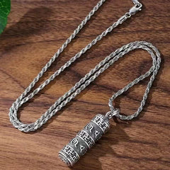 Copper Om Mani Padme Hum Necklace – Top-down view of cylindrical prayer wheel pendant with Tibetan mantra engravings on silver rope chain, spiritual pendant