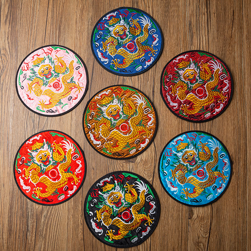 Dragon Embroidery Tea Cup Coaster Mat - seven colors flat-lay on wood, front-facing coiled dragon, black border trim