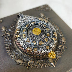 Zodiac Buddha Thangka Wealth Rotatable Pendant – angled closeup of silver relief border and golden Bagua center, detail