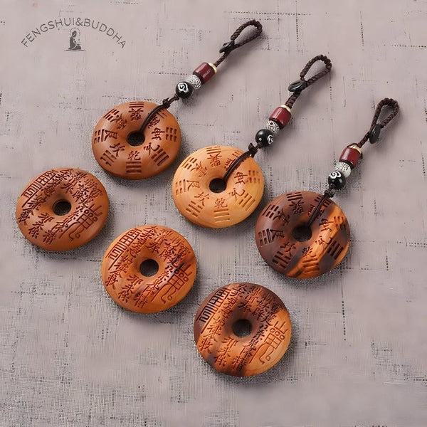 Peach Wood Bagua Coin – six coins arranged showing spell faces and Bagua backs, varied wood tones on grey linen, feng shui set