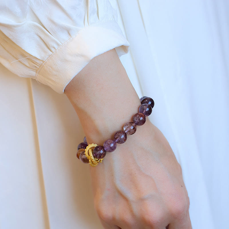 Purple Phantom Quartz Dragon Bracelet – Wrist lifestyle shot with natural stone variations and gold knot, soulful