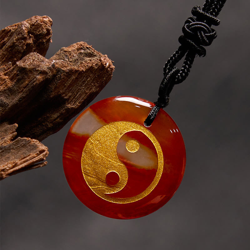 Yin Yang Crystal Necklace – Carnelian round pendant with gold yin-yang inlay, reddish-orange and white natural stone banding 