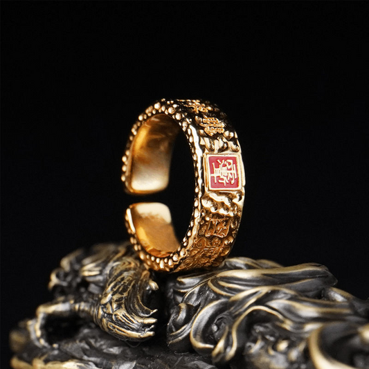 Tian Guan Ci Fu Ring – gold open ring with red seal and dragon carving on black stand, blessing protection amulet ring