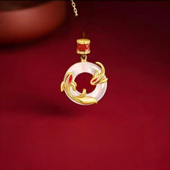 Koi Peace Necklace – close-up of gold koi and white circular pendant against deep red background, protection jewelry