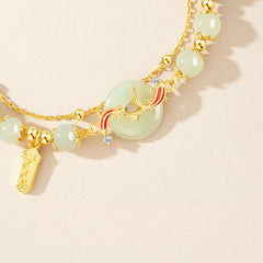Hetian Jade Bracelet – Close-up of pale green jade beads gold koi fish peace button with crystal details, women luxury