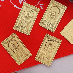 Guardian Gods Gold Foil Phone Sticker – four assorted deity gold foil stickers laid on red textured surface, including Akasagarbha, Manjushri and others, intricate embossed gold patterns, collection flat lay
