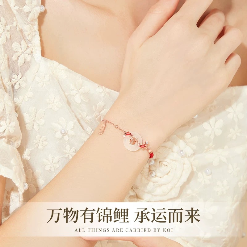 Koi Bracelet – Worn on wrist with white lace sleeve, rose gold jade peace button and red koi charm bracelet