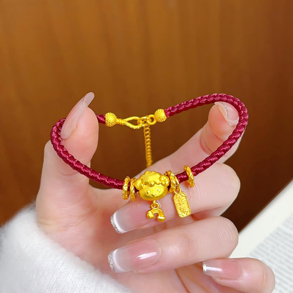 Ben Ming Nian Bracelet – gold ox charm held in manicured hand, brown wooden background, delicate