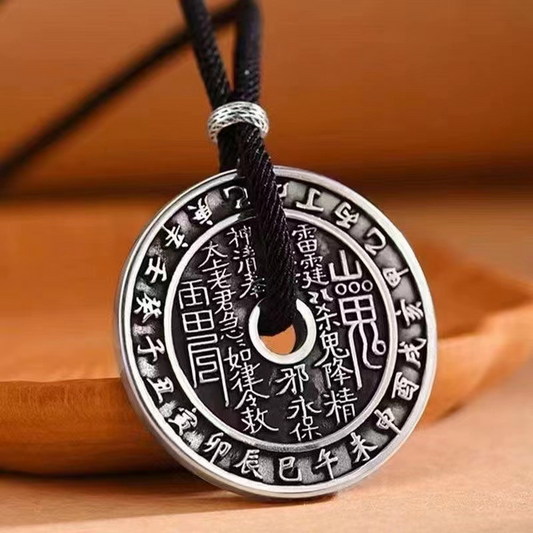Antique Shan Gui Pendant – silver round coin pendant with black cord on warm wood, outer zodiac characters, traditional Taoist protection amulet