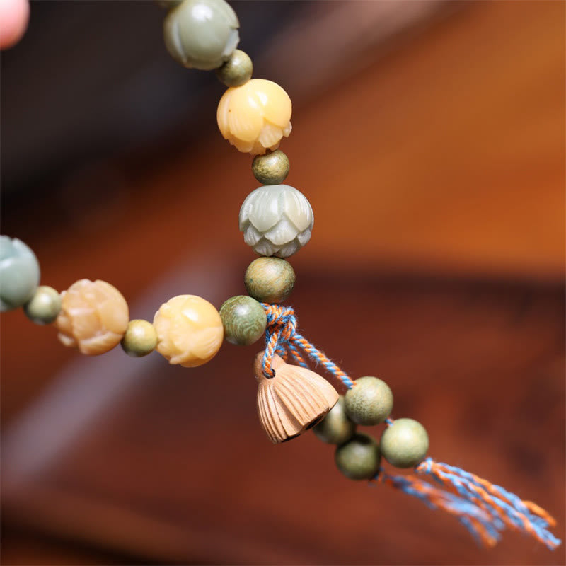 Bodhi Seed Green Sandalwood Lotus Bracelet – carved lotus pod tassel on warm wood surface, Serene