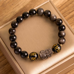 Silver Sheen & Black Obsidian PiXiu Bracelet – full top view on gold satin lining, black and silver sheen obsidian bead st...